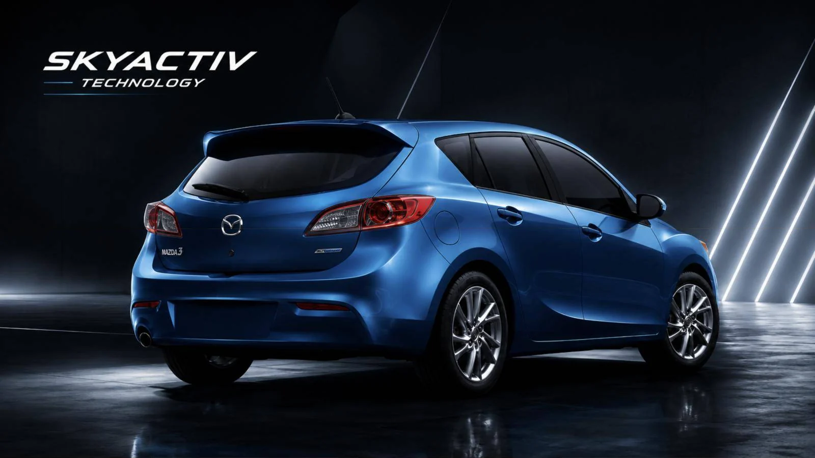 Blue Mazda3 hatchback in a dark studio with the SKYACTIV Technology logo